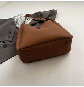 Macro detail of brown leather Hobo bag with vintage gold metal strap adjustment buckle