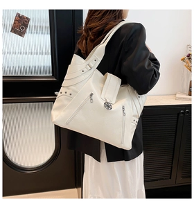 Detailed back view of a white textured faux leather tote bag with metal rivet accents