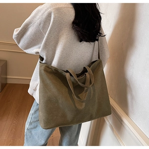 Detailed view of dark olive canvas tote bag featuring thick fabric and reinforced handles