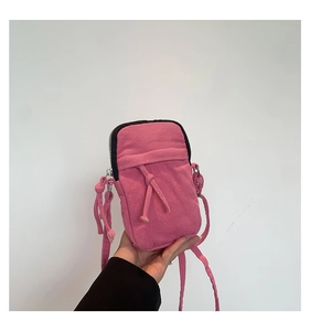 Detail view of the pink washed denim mini crossbody bag with a decorative knotted rope strap