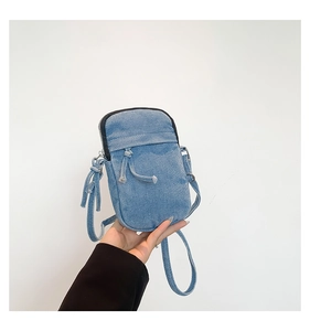 Detailed close-up of a blue washed denim crossbody mini phone bag with drawstring pocket
