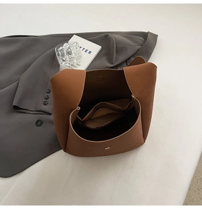 Top view of brown leather tote bag interior showing magnetic buckle and zipper pocket