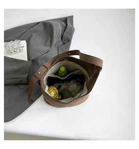 Top view of the spacious interior of a brown bucket bag with daily items inside