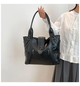 Detailed view of black PU leather tote bag with side zippers and decorative flower metal clasp