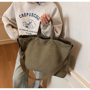 Detail of army green canvas tote bag with adjustable shoulder strap and large capacity