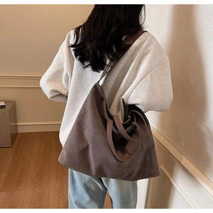 Detail view of the wide adjustable strap on the dark brown oversized corduroy tote bag