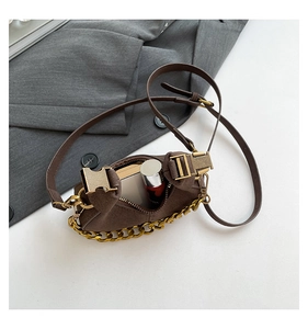 Primer plano de mini bolso bandolera de ante marrón con detalles de cadena e interior