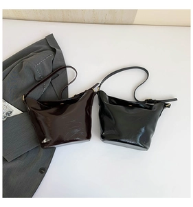 Detail view of retro patent leather bucket bags in chocolate and black colors
