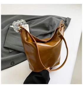Detail view of the caramel brown wrinkled leather texture and vintage gold metal buckle
