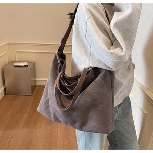 Detailed view of dark brown canvas tote bag with wide straps and spacious interior