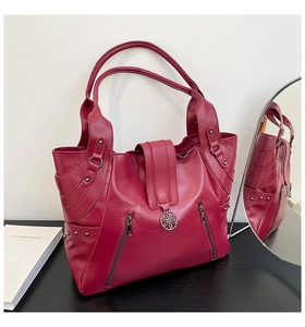 Detail of burgundy pebbled PU leather tote with zipper pockets and rivet accents