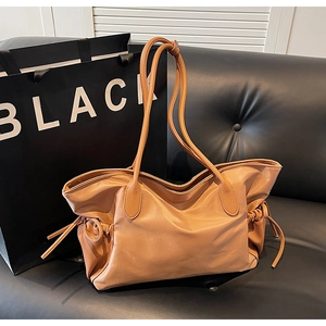 Détail du sac cabas caramel avec garniture en cuir et accents de cordon de serrage
