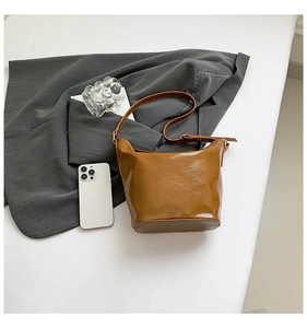 Detailed macro of vintage brown patent leather texture and gold buckle on hobo bag