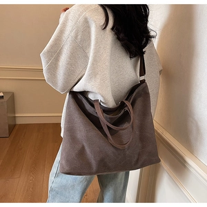 Detailed view of dark brown canvas tote bag showing large capacity and double straps