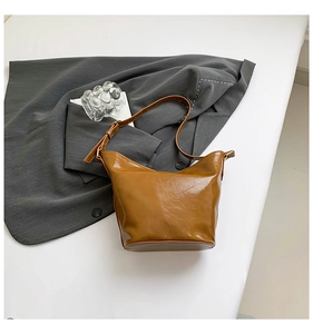 Macro shot of brown faux leather texture and golden metal buckle on bucket bag