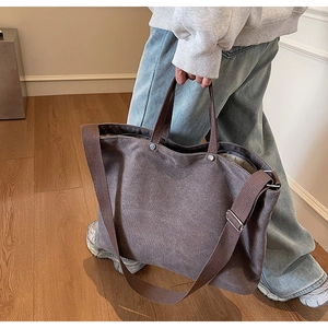 Detailed view of dark grey canvas tote bag with adjustable strap and sturdy handles