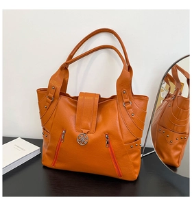 Detail view of the orange PU leather tote bag with floral buckle and zipper accents