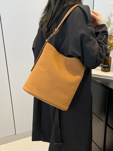 Brown suede bucket shoulder bag with minimalist design and adjustable strap for women