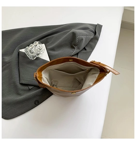 Internal view of brown leather bag showing spacious interior with zipper pocket and magnetic snap