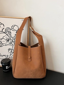 Minimalist brown matte faux leather tote bag with wide strap and gold adjustable buckle