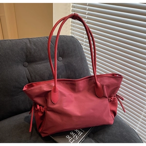Détail du grand sac de voyage rouge vin avec finitions de cordons décoratifs