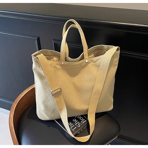 Close-up of a sturdy canvas tote bag with metal rivets and adjustable shoulder strap