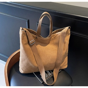 Macro detail of thick canvas fabric texture and sturdy straps on a khaki tote bag