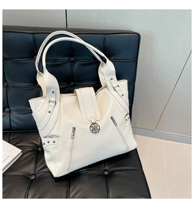Close-up of cream PU leather tote bag featuring lychee texture and side zipper details