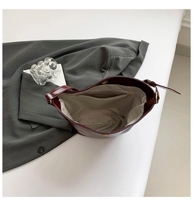 Top view of deep red bucket bag interior with grey fabric lining and zipper pocket