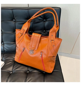 Detailed macro view of orange faux leather texture and decorative zipper on tote bag