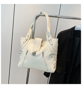 Detail of off-white lychee texture tote bag with diagonal zippers and metal floral buckle