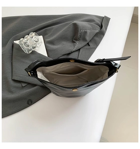 Internal view of black shoulder bag with magnetic snap and gold hardware detail