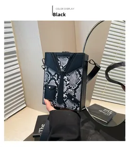 Detail of the black and white snakeskin box bag featuring a unique suit tie design and strap