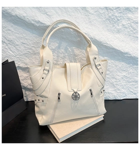 Detail of white tote bag featuring lychee texture leather and decorative metal floral buckle