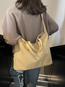 Large beige canvas tote bag with thick straps shown in a minimalist commuter scene