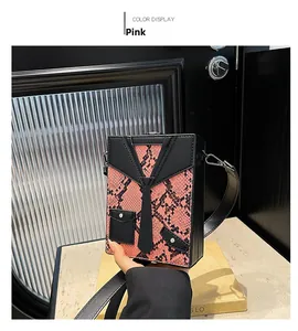 Detail view of pink snakeskin pattern box bag with creative tuxedo suit design elements