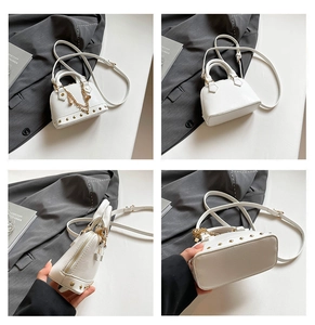Detailansicht der weißen Lederhandtasche mit goldenen Nieten und Kettenelementen