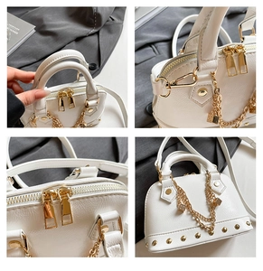 Details der weißen Muscheltasche aus Leder mit goldenen Nieten und Würfel-Anhänger