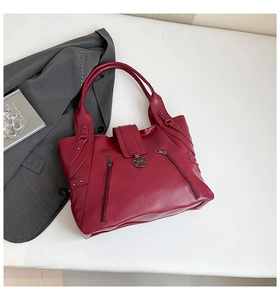 Detail of burgundy PU leather tote bag featuring flower buckle and decorative zippers