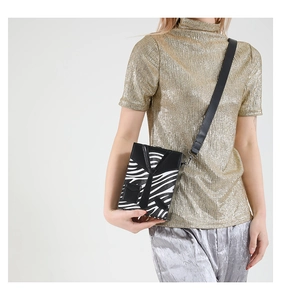 Fashionable tuxedo-style hard shell crossbody bag with zebra pattern on a model