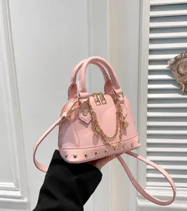 Detailansicht der rosa Muscheltasche mit Goldnieten, Doppelreißverschluss und Kettenanhänger