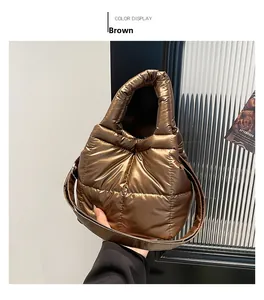 Détail d'un sac à main matelassé marron avec fini métallisé et poignée rembourrée