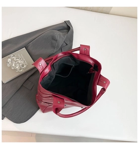 Macro detail of wine red tote bag interior with black lining and secure zipper pocket