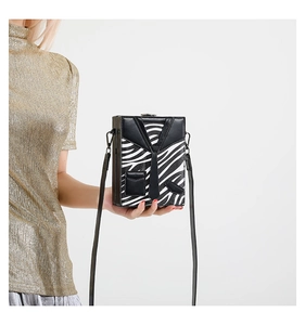 Detail of zebra pattern box bag featuring a creative suit design and metal clasp hardware