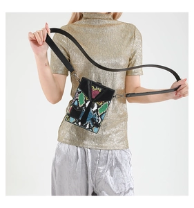 Close-up of a small square messenger bag with colorful snake print and V-shaped detail
