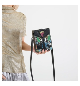 Detail of creative suit-tie design on a colorful snakeskin patterned hardshell crossbody bag