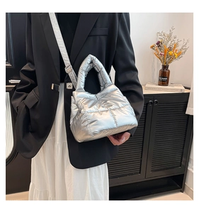 Detail of metallic silver down quilted handbag with adjustable shoulder strap