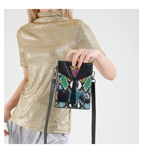 Detailed shot of creative tuxedo-style snakeskin crossbody bag on a fashion model