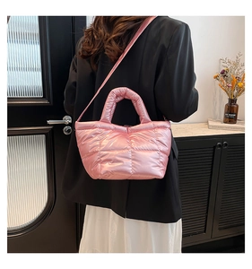 Quilted pink puffer tote bag shown on model with shoulder strap and satin finish