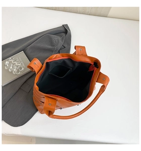 Detail showing orange PU tote bag interior with black lining and practical zipper pocket
